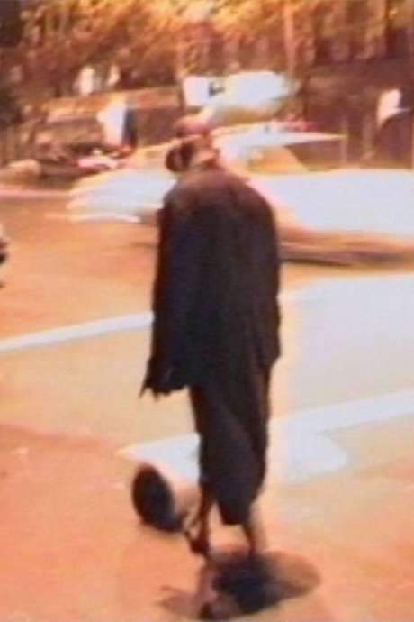 Phat Free opens with minutes of darkness and an unidentifiable metallic sound. When the image appears, Hammons—clad in a long coat, felt hat and sneakers—kicks a metal bucket along an empty city sidewalk at night. Filmed in 1995 to document his nocturnal performance and edited four years later, the harsh noise becomes a rhythmic, almost musical pulse that follows his deliberate movements, evoking rap‑hip‑hop lyricism and jazz improvisation.